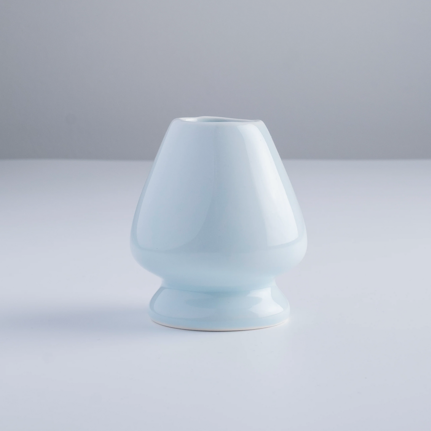 Light blue ceramic vase on a light gray background
